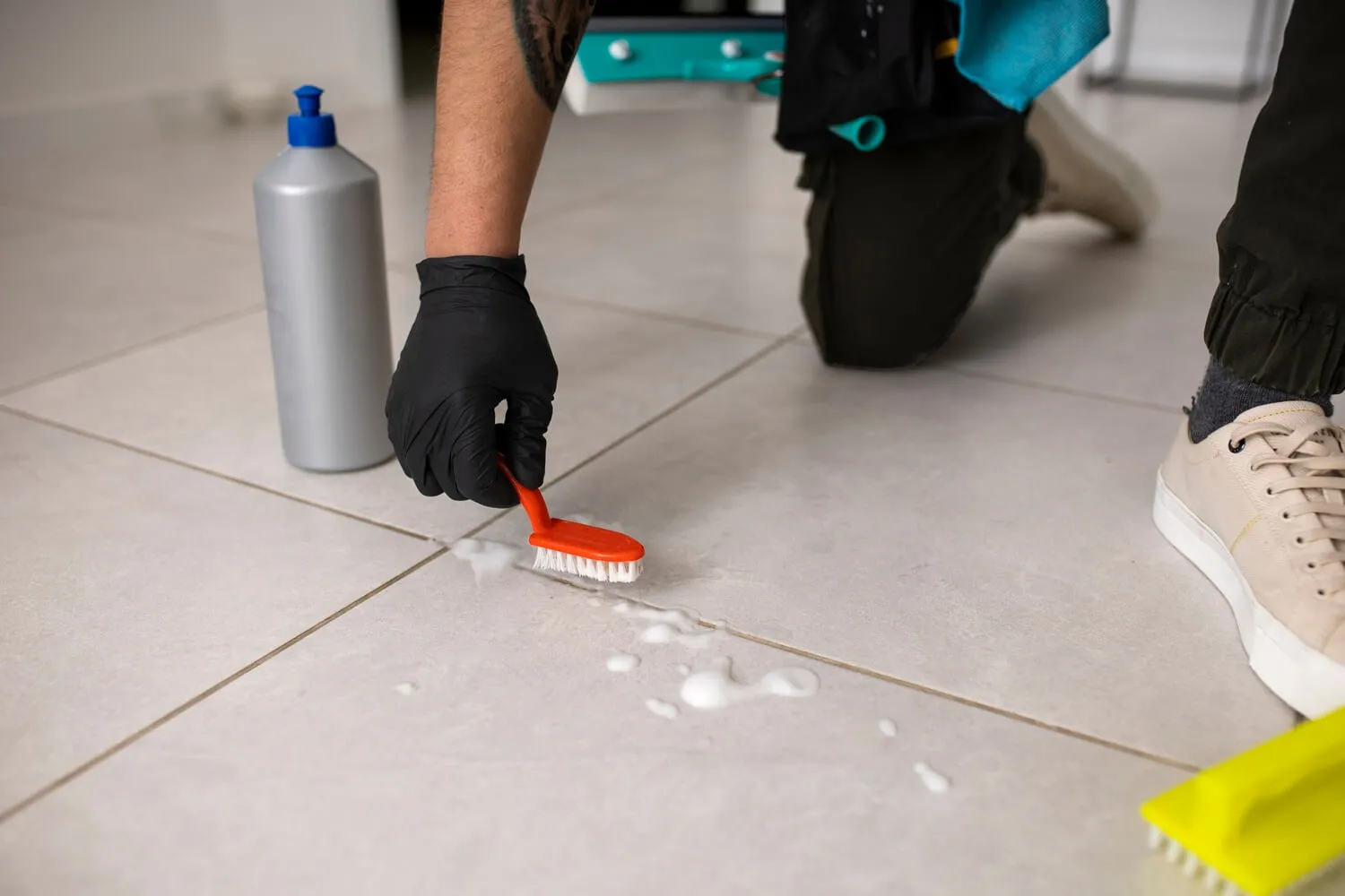 Applying-grout-sealer-with-a-small-applicator-bottle-and-brush